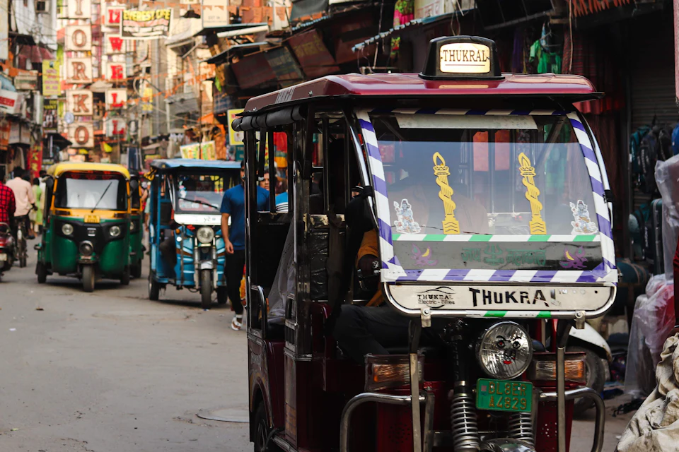 Auto rickshaw driving down a busy street