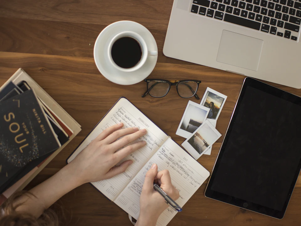 Person writing notes in a notebook for a blog article