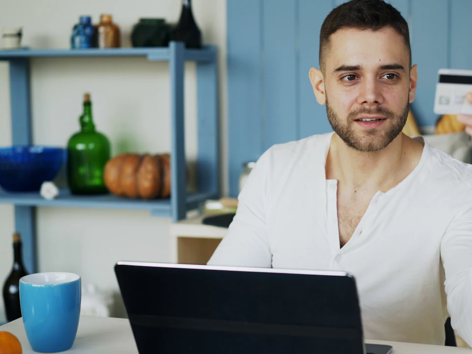 Customer shopping online with a credit card and laptop