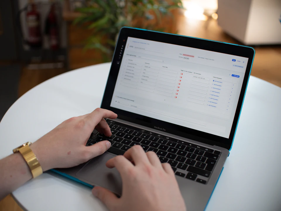 Hands working on a laptop with a spreadsheet