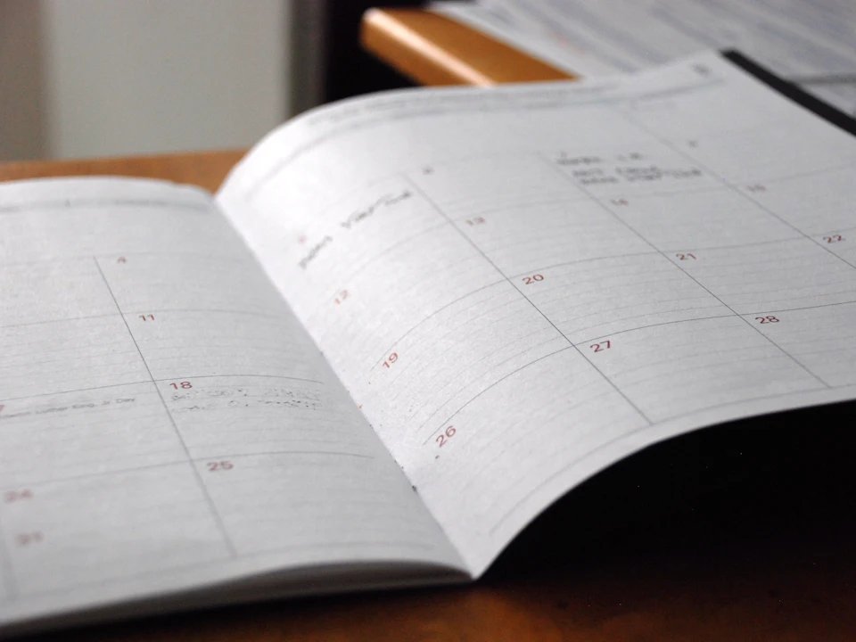 Open monthly content planner on a wooden desk