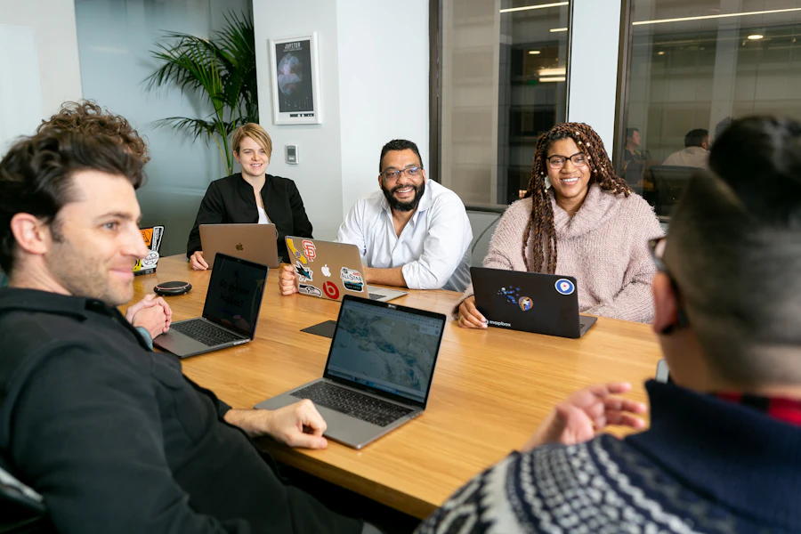 Team discussing a marketing plan around a table with laptops